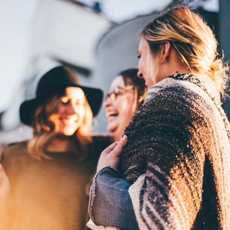 Three women laughing together outdoors
